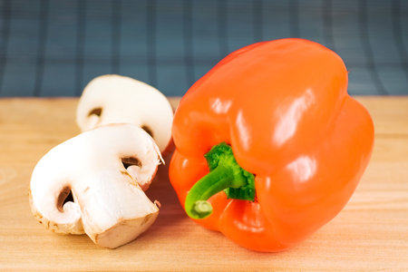 Pepper and mushrooms on a cutting boardの写真素材