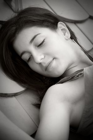 Beautiful young woman laying on a roofの写真素材