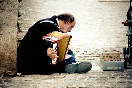 ATHENS, GREECE - FEBRUARY 04: Old serbian immigrant playing an accordion in downtown on February 04, 2010 in Athens, Greece.のeditorial素材