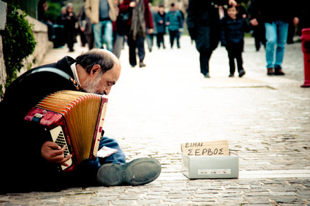 ATHENS, GREECE - FEBRUARY 04: Old serbian immigrant playing an accordion in downtown on February 04, 2010 in Athens, Greece.のeditorial素材