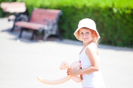 Little girl walking in the park with a baloon dog.の写真素材