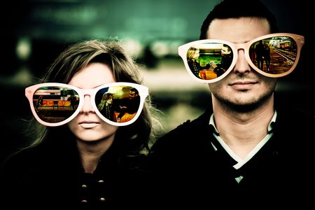Young couple wearing large glasses which reflect the beginning of their relationship.の写真素材