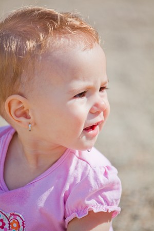 Small baby girl spending time outdoor on a warm autumn day.の写真素材