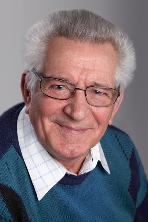 Portrait of an old man smiling, looking at camera, in studio.の写真素材