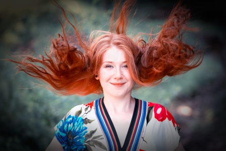 Portrait of a beautiful 20 year old redhead woman enjoying a summer day outdoor.の写真素材