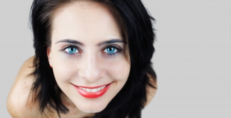 High angle view portrait of young brunette, cropped, isolated on grey.の写真素材