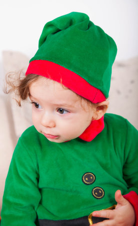 Portrait of a 1 year old baby boy dressed as an elf at home