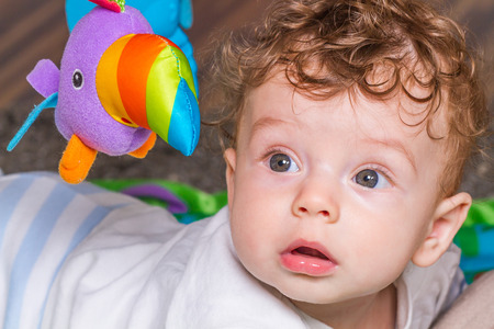 Portrait of a 7 months old baby boy at home with his toys.の写真素材