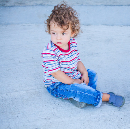 Portrait of 1 year old baby boy sitting on the ground.の写真素材