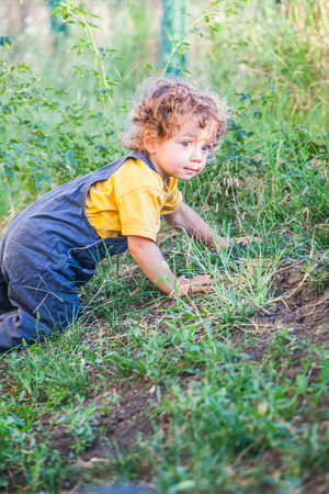 Portrait of 1 year old baby boy climbing a hill.の写真素材