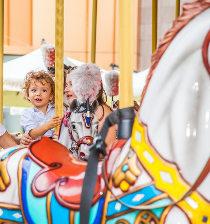 Baby boy having fun in a carousel.の写真素材