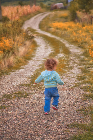 1 year old baby boy walking through the countryside.の写真素材