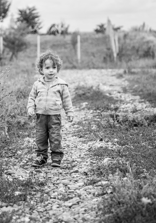 1 year old baby boy walking through the countryside.の写真素材
