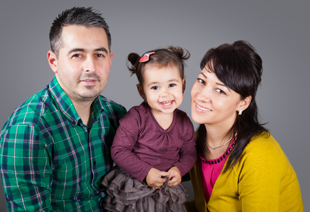 Parents with their 18 months old daughter, studio shot.の写真素材