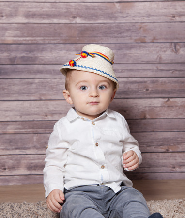 Portrait of a 1 year old baby boy wearing a Romanian traditional hat.の写真素材