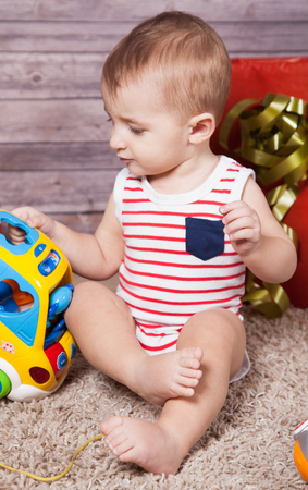Portrait of 1 year old baby boy, with presents, studio shot.の写真素材
