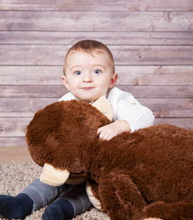 Baby boy portrait with a huge stuffed brown monkey toy.の写真素材