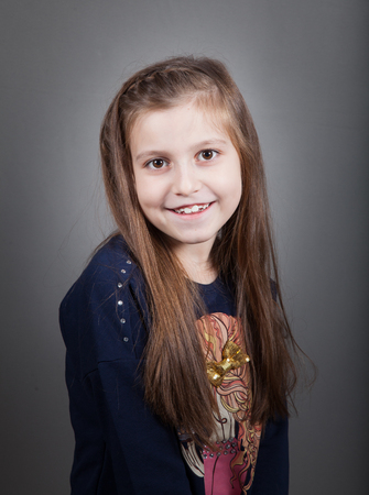 Portrait of a 8 year old girl, nicely dressed, studio shot.の写真素材