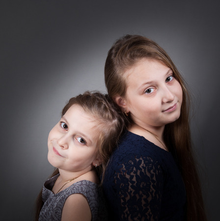 Portrait of8 and 10 year old sisters, studio shot.の写真素材