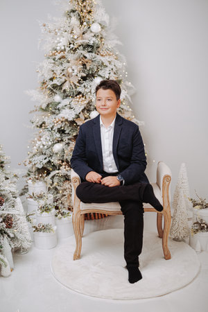 Studio portraits of 11 yeard preteen boy, in Christmas setting, dressed elegant.の写真素材