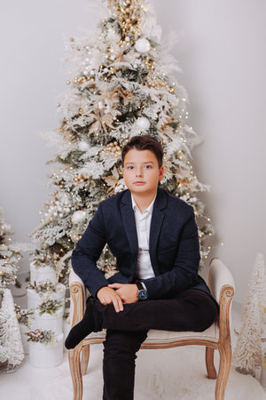 Studio portraits of 11 yeard preteen boy, in Christmas setting, dressed elegant.の写真素材