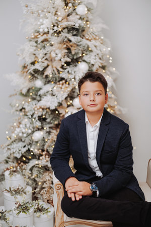 Studio portraits of 11 yeard preteen boy, in Christmas setting, dressed elegant.の写真素材