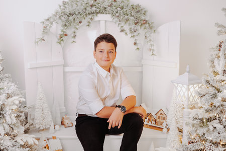 Studio portraits of 11 yeard preteen boy, in Christmas setting, dressed elegant.の写真素材
