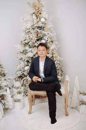 Studio portraits of 11 yeard preteen boy, in Christmas setting, dressed elegant.の写真素材