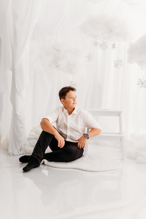 Studio portraits of 11 yeard preteen boy, in Christmas setting, dressed elegant.の写真素材