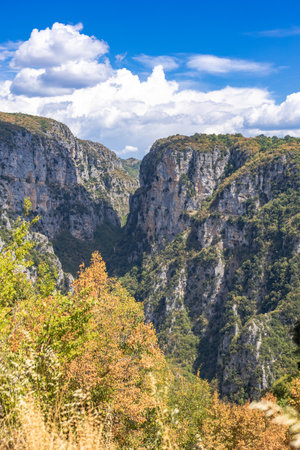 Majestic view of Vikos Gorge in Zagori, Epirus, Greece, one of the deepest canyons in the world. The scene captures dramatic cliffs, lush greenery, and rugged terrain under natural sunlight, offering a breathtaking perspective of this iconic hiking and adventure destination. Ideal for travel, nature, and landscape photography.の写真素材
