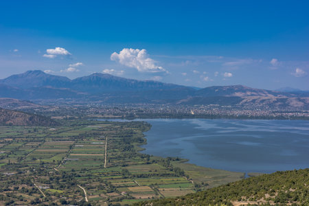 Stunning aerial view of Ioannina Lake (Pamvotida) in Greece, as seen from the nearby mountains, with the cityâs buildings nestled along the shoreline. A perfect blend of urban and natural beauty, capturing the charm of this historic region in Epirus. Ideal for travel, tourism, and landscape photography.の写真素材