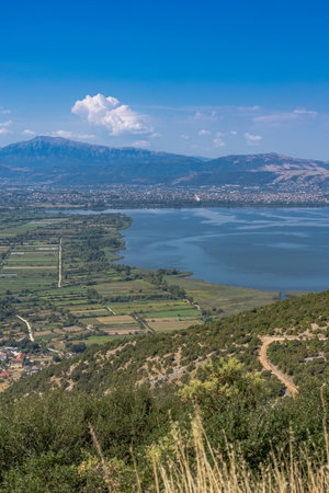 Stunning aerial view of Ioannina Lake (Pamvotida) in Greece, as seen from the nearby mountains, with the cityâs buildings nestled along the shoreline. A perfect blend of urban and natural beauty, capturing the charm of this historic region in Epirus. Ideal for travel, tourism, and landscape photography.の写真素材