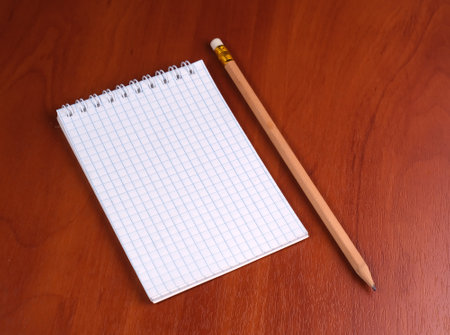 notepad with pencil on wood tableの写真素材