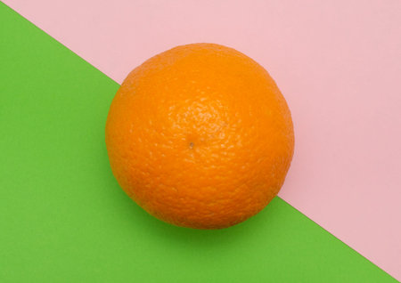 Orange citrus fruit on colored geometric green pink background