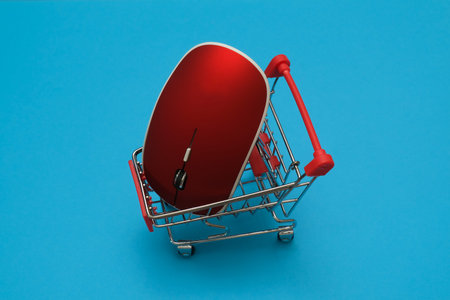 shopping cart trollye with red computer mouse on blue background