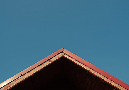 red old house roof on blue sky background