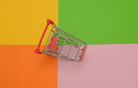 empty shopping cart trolley on colored backgroundの写真素材