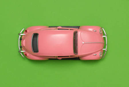 pink vintage retro car toy top view on green backgroundの写真素材