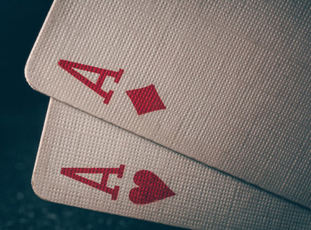 Macro shot texture of playing cards. A pair of aces on a black background. Ace of hearts and ace of diamonds. Nuts hand a pair of aces to win. Close-up image a pair of aces.の写真素材