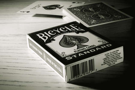 Russia, Saint-Petersburg, 12 June 2022: A deck of Bicycle Playing Cards Standart and Ace of spades on a wooden background-black and white photo.のeditorial素材