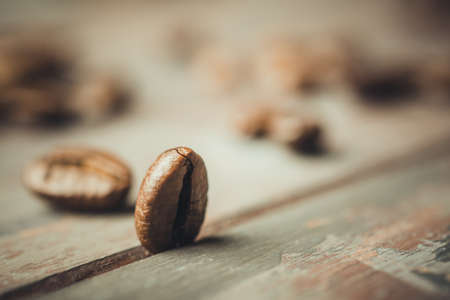 Roasted coffee beans on the old wooden table. Coffee bean close up shot. Coffee beans background. High quality photo.の写真素材