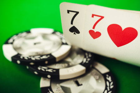 Seven of hearts and seven of spades. A pair of sevens and poker chips on a green background, poker...