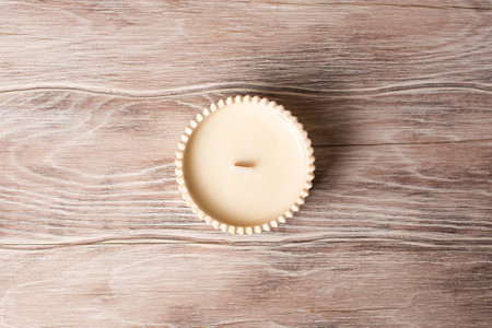 Scented handmade candle on a wooden background. Soy candle Aromatherapy and relax in spa and home.の写真素材