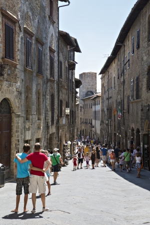 SAN GIMIGNANO - AUGUST 17; Tourists in San Gimignano on August 17, 2012  San Gimignano is a small walled medieval hill town in Tuscany, Italy のeditorial素材