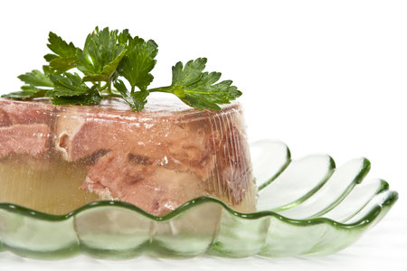 Jellied beef tongue in a pretty bowl on a white background. 