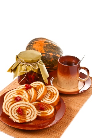 Cakes with jam from a pumpkin and a cup of tea on a napkin out of the straw の写真素材