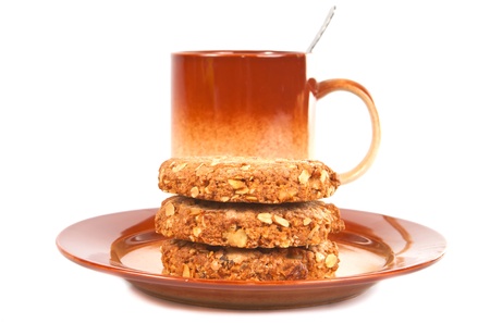Several oat biscuits with peanuts and dried apricots on a plate on a white background  の写真素材