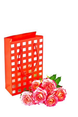 Red gift bag and a bouquet of beautiful roses の写真素材