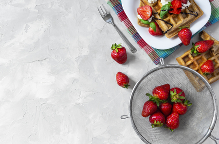 Homemade waffles with strawberries, ricotta cheese and chocolate on white plate. Flat lay, copy spaceの写真素材