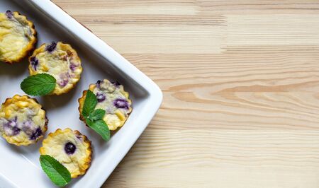 cheese blueberry muffins in a dish on a wooden background. flat lay, copy spaceの写真素材